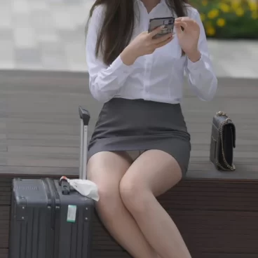屋外のベンチに座ってタイトミニから股間の白パンティをパンチラさせるOL